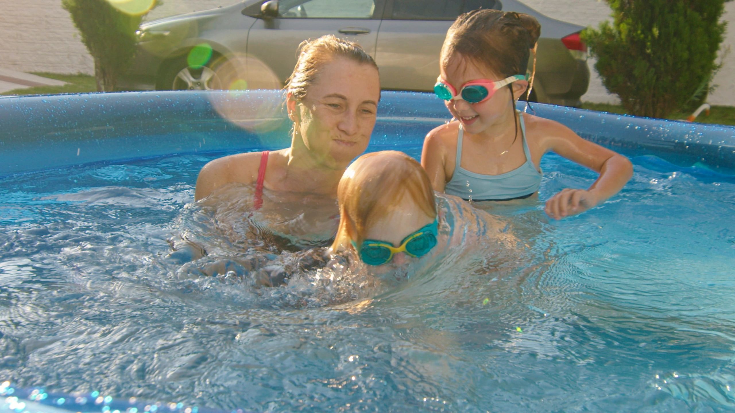 Family relaxing by a backyard swimming pool
