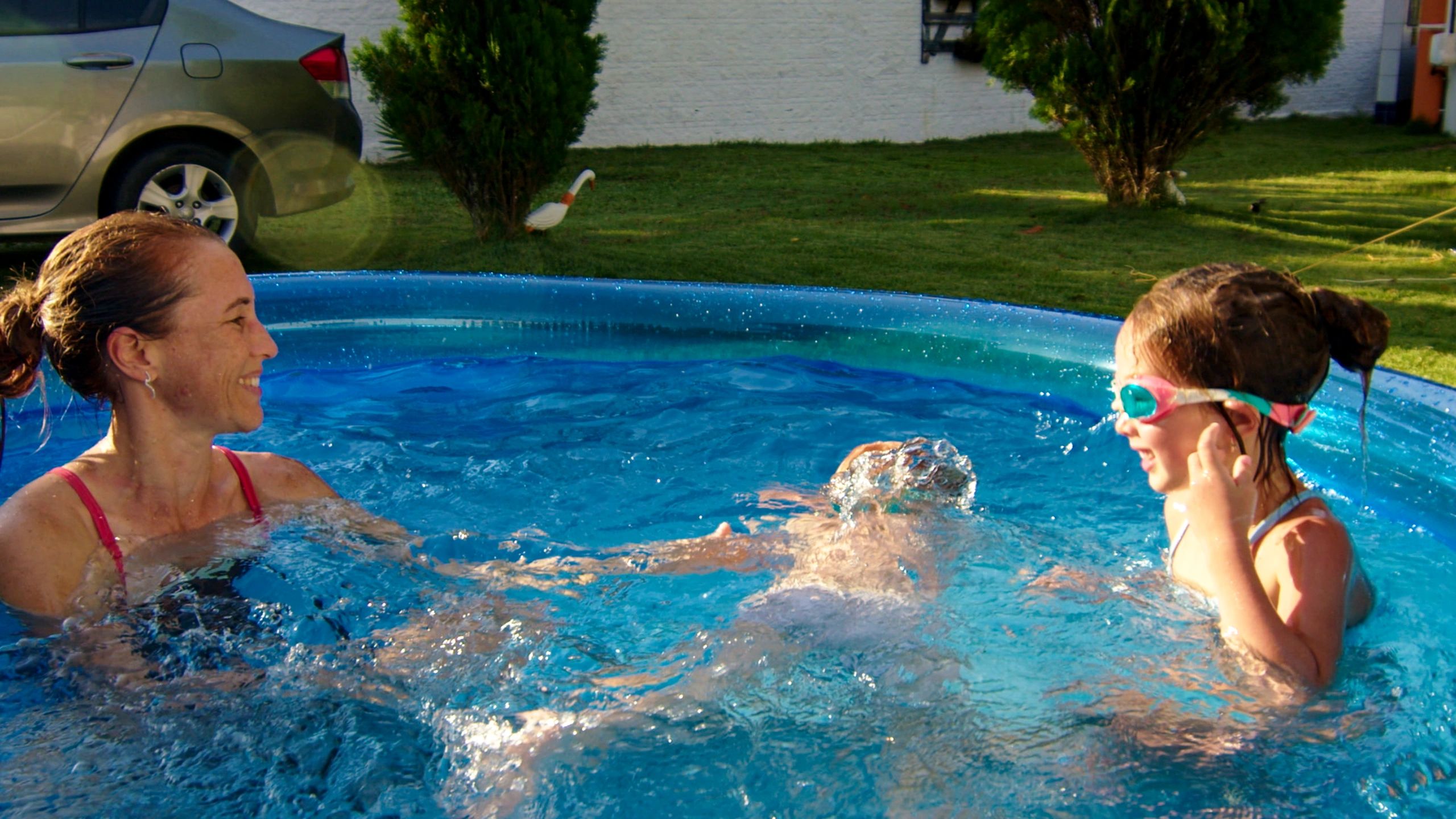Family enjoying time near a backyard swimming pool